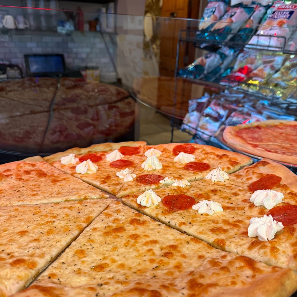 Amore Pizza and Pasta's pepperoni and cheese pizza with ricotta dollops, alongside plain cheese slices.